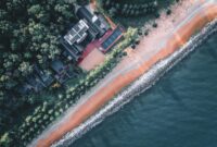 Sareeraya Villas Suites Aerial shot of villas by a beautiful shoreline with forest and beach.